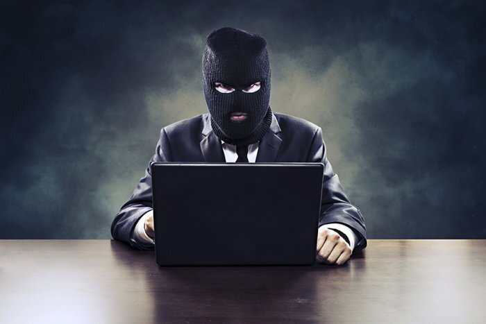 A masked hacker prepares to engage in online mischief.